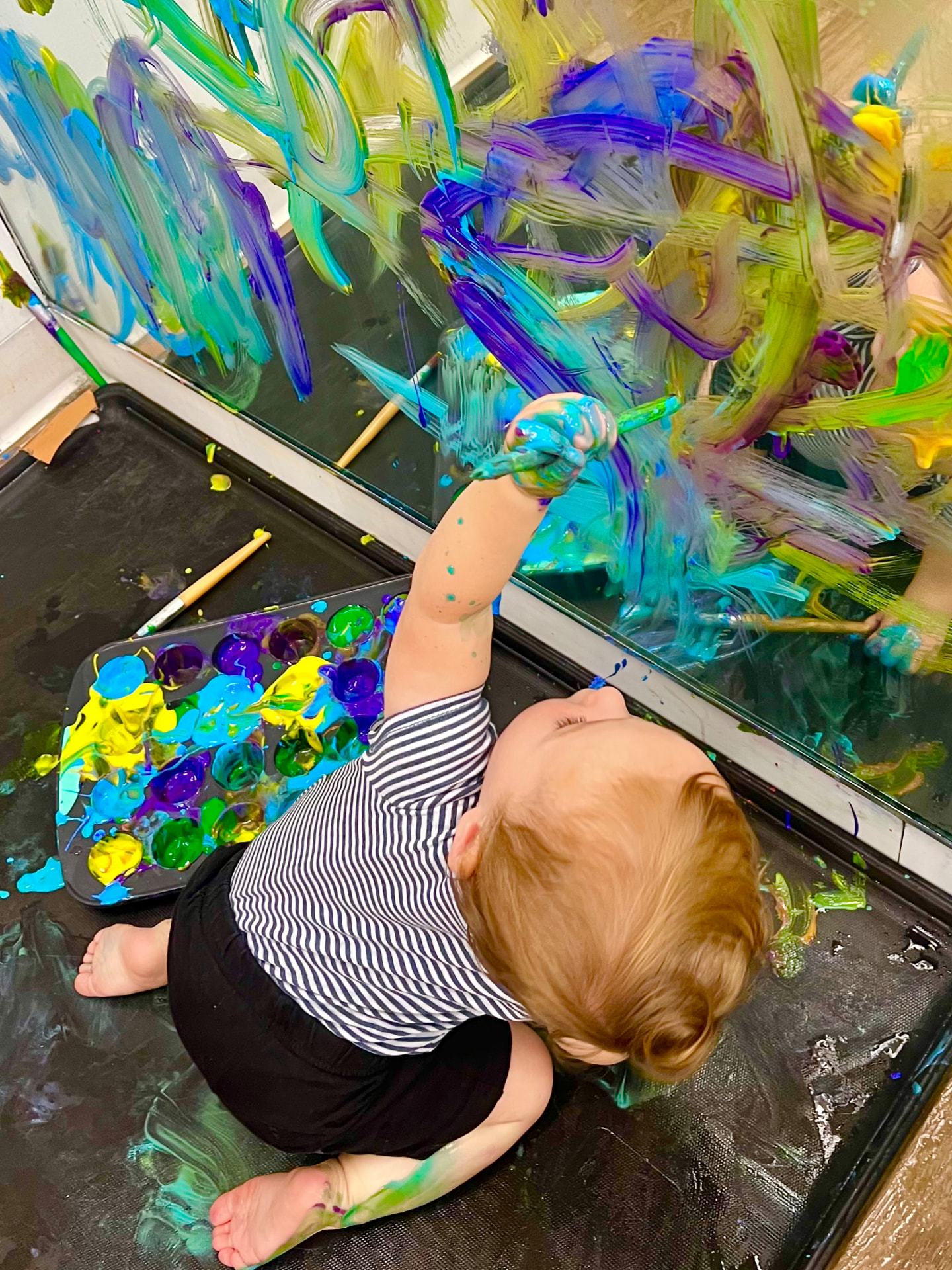 Toddlers making colorful handprint art