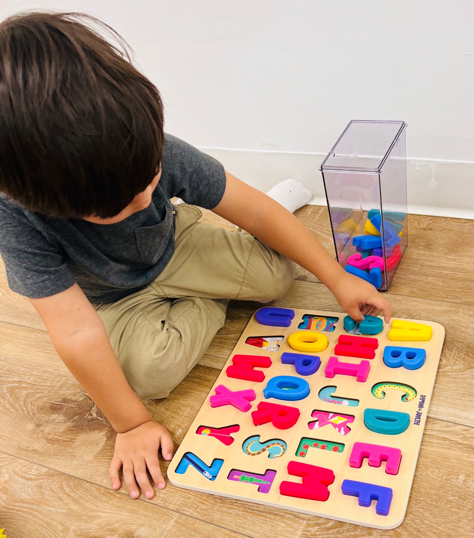 Child completing a colorful alphabet puzzle