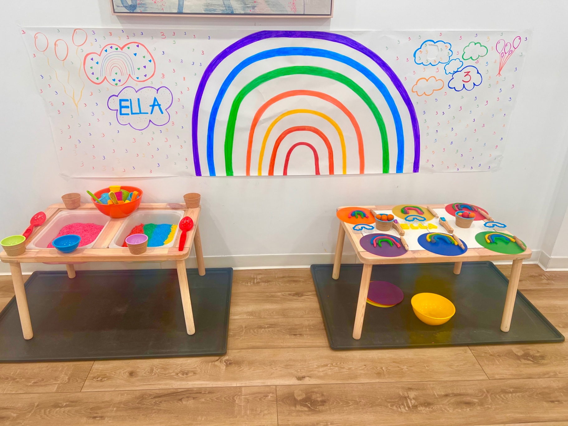 Rainbow mural with Ella name and sensory play tables